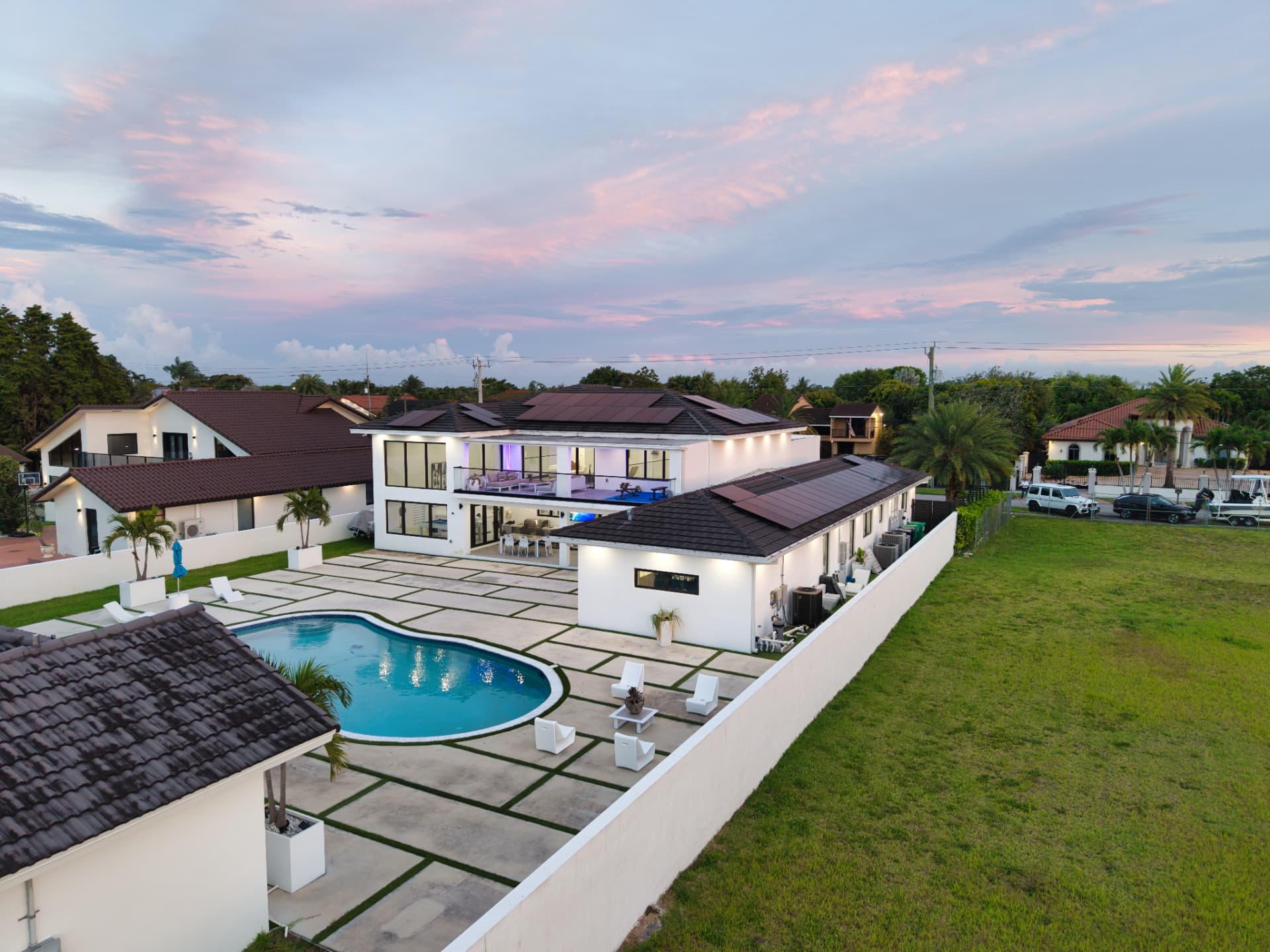 Aerial twilight view of a modern Miami estate with freeform pool